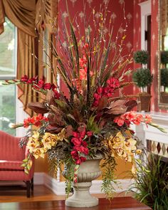 a large vase filled with flowers on top of a table next to a fire place