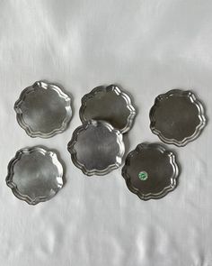 four metal trays sitting on top of a white sheet