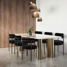 a dining room table with black chairs and a white marble top