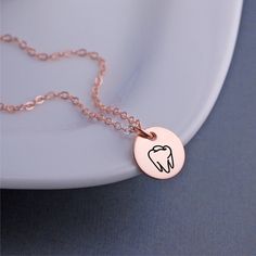 A 12mm (1/2 inch) disc is engraved with a tooth outline. Metals available include 14k rose gold filled, 14k gold filled and stainless steel pendant with sterling silver filled chain. Lengths available include 16, 18 or 20 inches. **ALL charms are optional! (shown with 1 added initial charm). Choose from initials, Swarovski crystal birthstones or other symbols. Hypoallergenic Rose Gold Jewelry For Personalized Gifts, Hypoallergenic Rose Gold Charm Necklace With Round Pendant, Minimalist Rose Gold Charm Necklace, Rose Gold Charm Necklaces With Round Pendant, Minimalist Rose Gold Hand Stamped Charm Necklaces, Minimalist Hand Stamped Rose Gold Charm Necklace, Minimalist Rose Gold Hand Stamped Charm Necklace, Hypoallergenic Rose Gold Sterling Silver Charm Necklace, Hypoallergenic Rose Gold Round Charm Necklace