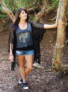 a woman standing next to a tree with her arms spread out in front of her