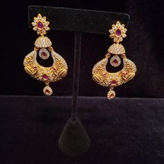 "These Jhumka Earrings set have an excellent finish and gives out an exquisite sense of style. If you are looking for an amazing Fashion Jewelry set for special occasions such as Anniversary, Engagement, Party, Wedding or for gifting , then your search ends here. Handmade Indian Temple Jewelry, best to wear it for traditional ceremonies or Indian wedding. This bridal jewelry has ethnic finish. It has Cubic Zircon stones with ruby and emeralds. It is a Bollywood style one gram jewelry. There are Jeweled Pearl Earrings For Wedding And Festivals, Jeweled Pearl Earrings For Wedding, Kundan Earrings With Peacock Design For Celebrations, Traditional Jeweled Pearl Earrings For Celebration, Formal Bollywood Chandbali Jewelry Sets, Hand Set Hoop Earrings For Wedding, Traditional Drop Plug Earrings For Formal Occasions, Traditional Jeweled Pearl Earrings For Wedding, Traditional Formal Drop Plug Earrings