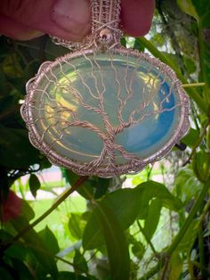 Silver Moonstone (Opalite) tree of life pendant, Wire wrap family Tree necklace, Tree of life pendant, Double sided pendant  Material: silver plated wire Details:  Pendant dimension:  2,5 x 2 inch Chain length: 24 inch Color: blue This beautiful Tree of Life necklace is hand-crafted unisex necklace with Opalite  and Silver plated wire. Opalite is a milky man-made stone of translucent glass and crushed opals. It can transform from a rainbow sheer to a bright blue to flashy yellow depending on the light. The pendant in the photos was shot in natural sunlight Tree of Life symbol crosses all cultures and stems back to our ancient ancestors. It represents wisdom, strength, prosperity, protection, beauty and connection to our Earth. This pendant made with good intentions and love! One of a kind, Unique Tree Of Life Jewelry Gift, Unique Tree Of Life Round Pendant Jewelry, Mystical Wire Wrapped Jewelry For Gifts, Nature-inspired Moonstone Jewelry Gift, Unique Tree Of Life Round Jewelry, Spiritual Tree Of Life Jewelry Gift, White Tree Of Life Jewelry Gift, Spiritual Tree Of Life Jewelry For Gifts, Spiritual Tree Of Life Jewelry As A Gift