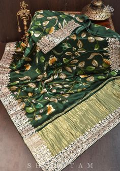 This Gajji Silk Saree by Shobitam is sure to add a touch of elegance to any special occasion. It features a stunning floral digital print and Gotta Patti borders with crushed zari palla, a traditional crafting technique from Rajasthan. Soft and lustrous, it comes with falls and pico done and an unstitched blouse fabric included. Elevate your look with this beautiful saree. Note: Colors that show up on your screen may vary slightly from the actual product due to variations in settings. Also, the Elegant Banarasi Silk Meenakari Sets, Elegant Meenakari Banarasi Silk Sets, Green Meenakari Raw Silk Traditional Wear, Green Raw Silk Traditional Wear With Meenakari, Green Traditional Wear With Meenakari In Raw Silk, Celebration Art Silk Saree With Meenakari, Celebration Saree In Art Silk With Meenakari, Elegant Meenakari Salwar Kameez For Eid, Elegant Meenakari Salwar Kameez For Festive Occasions