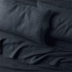 black linen sheets and pillows on a bed