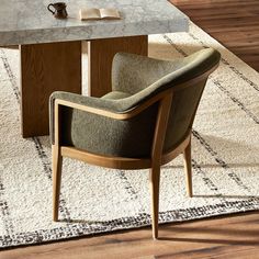 a chair sitting on top of a rug in front of a table with a book