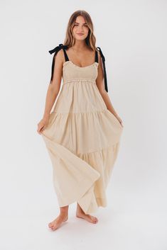 This dress is the perfect blend of femininity and contemporary comfort - meet the Amber Maxi Dress, a sweet and effortless gown for your next special event. We love its unique smocked bodice with a charming sweetheart neckline, plus self-tie shoulder straps in a sleek black hue. Pair this beauty with heels or slides and prepare yourself for the compliments! Available in two colorways. FIT: Runs true to size. Bodice is smocked and stretchy, but empire waist gives it a fitted structure that can be restricting for larger chests. Size up if you are between sizes. MATERIAL: GARMENT DETAILS: Lightweight maxi dress with empire-waisted silhouette and self-tie shoulder straps in contrasting color. Features a smocked bodice with sweetheart neckline, and a full, multi-tiered skirt. SIZE GUIDE: XS (0- Brunch Maxi Dress With Ruched Bodice, Maxi Dress With Ruched Bodice For Brunch, Sundress With Smocked Bodice For Gatherings, Sleeveless Dress With Smocked Back For Gatherings, Casual Dress With Smocked Back For Gatherings, Spring Dresses For Gatherings With Smocked Back, Sundress Maxi Dress With Ruched Bodice For Brunch, Spring Gatherings Dress With Smocked Back, Chic Smocked Maxi Dress For Daywear