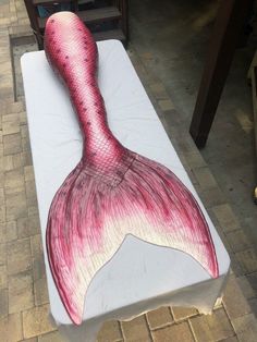 a bench that has been painted to look like a mermaid's tail on it