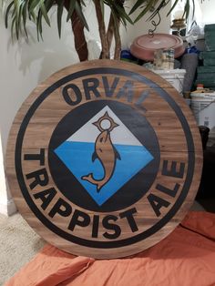 a wooden sign that says orvist trappist ale on it in front of a potted plant