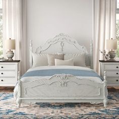 a white bed sitting in a bedroom on top of a blue rug