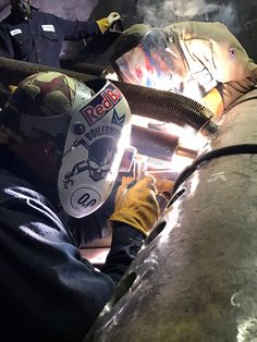 welders working on the back of an industrial machine