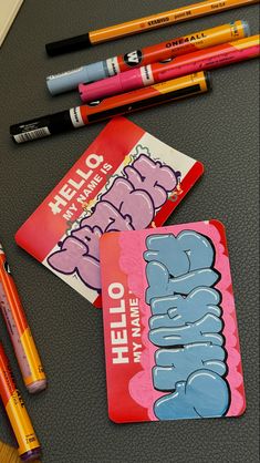 there are pencils and markers on the table next to some cards that say hello