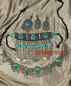 We call this the "Baran Set" - It translates to rain.  This is a traditional jewelry set originated and inspired by classic Afghan fashion. This set contains 5pcs: Necklace, Pair of earrings, belt and a Matika (Headpiece).  Colors: Silver and Blue  Necklace: 6.5 " drop Earrings:  4 " Matika: 5 " Belt: 49 " Please note: As this piece is completely handmade, minor discrepancies may be present. These imperfections contribute to making it a unique and one-of-a-kind piece.  Care Instructions: Clean t Balochi Doch Jewelry, Bohemian Ceremonial Jewelry With Stone Work, Traditional Turquoise Jewelry Sets For Wedding, Bohemian Jewelry With Stone Work For Celebration, Bohemian Stone Work Jewelry For Celebration, Bohemian Jewelry For Festivals With Stone Work, Bohemian Festival Jewelry With Stone Work, Bohemian Jewelry With Stone Work For Festivals, Handmade Turquoise Jewelry For Festive Occasions