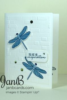 a close up of a card with dragonflies on it