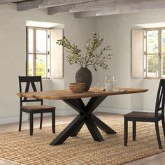 a dining room table with chairs and a vase on the table in front of it