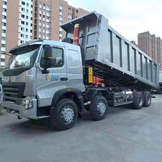 a silver dump truck parked in a parking lot