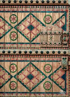 an ornate wooden door with decorative designs on the front and side panels, painted in multi - colored paint