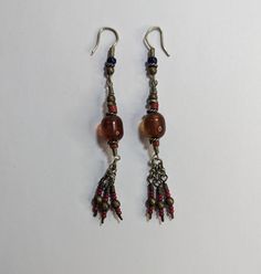 Vintage Handmade Artisan Beaded Earrings Dangle Drop Brown Red Glass Beads Twisted Wire Details 3" Tassel Ends Approximately 3" long Dangle Earrings With Silver Beads For Festivals, Silver Beaded Dangle Earrings For Festivals, Festival Dangle Earrings With Silver Beads, Red Traditional Beads For Crafting, Traditional Red Beads For Crafting, Traditional Large Beaded Earrings For Gifts, Dangling Beads For Gifts And Festivals, Handmade Traditional Metal Beads, Artisan Colorful Dangle Beads