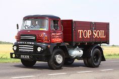 a large red truck driving down a road