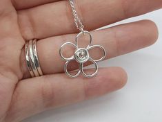 Cute sterling silver flower necklace pendant, handmade in the UK This quirky daisy flower is made from 100% recycled sterling silver wire and will be made to order. I hand form these flowers myself, so each one is unique. Reminiscent of forget me nots, the pendant will be sent on a delicate sterling silver curb chain but you could of course add it to your own chain later if you prefer. Sterling silver flatters all skin tones and can be worn with any outfit. You will not be disappointed with this Handmade Minimalist Flower Pendant Necklace, Minimalist Handmade Flower Pendant Necklace, Handmade Dainty Sterling Silver Flower Necklace, Adjustable Sterling Silver Flower Necklace, Handmade Sterling Silver Flower Pendant Necklace, Sterling Silver Flower Necklace, Daisy Pendant, Silver Flower Necklace, Necklace Cute