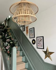 the stairs are decorated with christmas garlands and star decorations, along with pictures on the wall