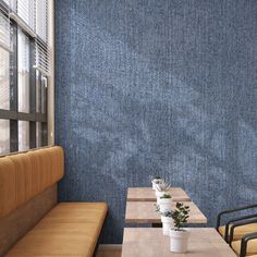 two wooden tables sitting next to each other in front of a blue wall with vertical blinds