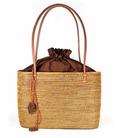 The Lisi Lerch Bali Bag collection is all handwoven by local artisans of the Tenganan region of Bali. Each weaver creates these works of art by using ata grass, a vine indigenous to the foothills of volcanoes on their beautiful Indonesian Island. The bags are then smoked in a coconut and honey fire to achieve their luscious golden hue. Our amazing team in Baltimore then adorns each bag so that they are as unique in character as the women who carry them. Whether you are strolling down the cobbled streets of Nantucket, sipping rosé in Charleston, or sunbathing poolside at your favorite resort, these one of a kind bags will surely turn heads! Size 7Wx5Hx4D 48 inch strap Materials Hand Woven Ata Grass Genuine Leather Strap Lining: Hand Loomed Cinnamon Cotton Features Drawstring Closure Crossbo Fair Trade Straw Bag For Travel, Brown Straw Bag With Bamboo Handle For Travel, Eco-friendly Woven Straw Travel Bag, Eco-friendly Weaved Straw Bag For Travel, Eco-friendly Woven Straw Bag For Travel, Eco-friendly Natural Shoulder Bag With Weaving, Eco-friendly Straw Travel Bag With Weaving, Natural Fiber Woven Straw Travel Bag, Woven Natural Fiber Straw Bag For Travel