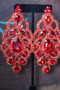 "These fun and stylish extra wide crystal rhinestone earrings are a great statement piece! Size of earrings: 2.25\" Wide and 4.5\" Long. Color: red Base metal: gold Style: pierced and clip on available! More colors available upon request, just message us! Looking for a matching bracelet? https://www.etsy.com/listing/538148439/red-crystal-bracelet-large-crystal?ref=shop_home_active_33 Looking for the perfect pair of earrings for a special occasion. We specialize in custom work in fashion jewelry, Traditional Luxury Red Chandelier Earrings, Red Prom Earrings, Red Glamorous Chandelier Earrings For Party, Glamorous Red Chandelier Earrings For Party, Red Glamorous Chandelier Earrings For Evening, Glamorous Red Chandelier Earrings For Evening, Glamorous Red Crystal Earrings For Evening, Red Crystal Rhinestone Earrings For Party, Red Rhinestone Crystal Earrings For Party