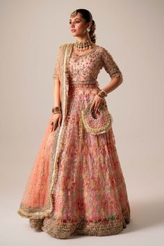 Pakistani Bridal Dress in Organza Choli Lehenga Style is adorned with hand-crafted details of dabka, gota, kora, naqshi, and threads. The choli has an alluring pink shade and the Bridal Lehenga is multi-colored, creating a lavish Lehenga Dress for the bride to wear on the big day. Detailed Description: SKU: BS2482 Detailing: Embroidery, Motifs, Naqshi, Sequins, Dabka, Gota, Kora, Threads Color: Pink, Multi-color Fabric: Organza, Net Design: Fully Embellished Dress with Embroidery Event: Bridal wear, Wedding Traditional Designer Lehenga With Dabka Work, Traditional Gown With Pallu For Transitional Season, Traditional Gown With Pallu For Eid, Traditional Organza Sets For Reception, Traditional Organza Reception Sets, Traditional Gown With Pallu For Designer Wear, Dola Silk Dresses With Dori Work For Festivals, Designer Traditional Gown With Pallu, Traditional Organza Salwar Kameez For Reception