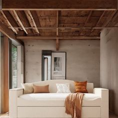 a white couch sitting under a wooden ceiling