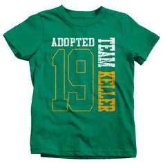 "Kids Personalized Adopted T Shirt Matching Custom Matching Family Shirts Adoption Adopting Tee Athletic Team TShirt Toddler Let everyone know that you're officially become a family in this personalized adoption t shirt. This tee will be personalized with your family name and year. Please leave the name, year, and print color preference in the notes section at checkout. The design is big, bold and athletic styled. It will feature the last two digits of the year the adoption happened as well as t Green Short Sleeve Team Spirit T-shirt, Green Graphic Tee With Team Name, Green Crew Neck Top With Team Spirit Style, Green Crew Neck Top For Team Spirit, Green Team Spirit Short Sleeve T-shirt, Green Short Sleeve T-shirt With Team Spirit Style, Green Short Sleeve Top For Team Spirit, Casual Green Shirt With Name Print, Green Casual Shirt With Name Print