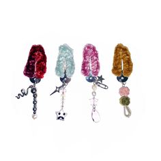 four different colored hair ties with beads and charms hanging from each one's side