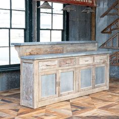 an old fashioned wooden counter in front of large windows