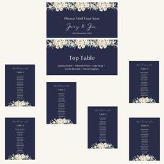 wedding seating cards with white flowers on navy blue and silver foiled paper, which reads top table