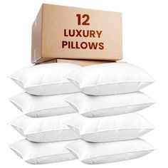 twelve white pillows in front of a cardboard box