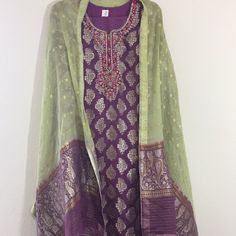 Elegant Purple And Green Jamawar Embroidered Dress-3 Pcs- Shirt Is Jamawar With Gold Embroidery Of Dabka And Stones-Long Sleeves- Scarf Is 2.5 With Purple And Green Contrast, Chiffon, Jamawar Work. Pant Is Plain Purple, Polyester, Straight And Elastic. Shirt Length 45 Inches Chest 22 Waist 21 Hips 24 Shoulders 16 Sleeves 21.5 Trouser/ Pant Length 38.5 Inches Waist 14.5 To 18.5 Inches Inseam 14 Inches Opening Of Bottom- 9 Inches Purple Sharara For Transitional Season, Purple Chanderi Sharara With Pallu, Purple Cotton Silk Straight Kurta, Purple Chanderi Sharara With Traditional Drape, Traditional Purple Sharara With Sheer Dupatta, Purple Sharara With Sheer Dupatta In Traditional Drape, Purple Sharara With Sheer Dupatta And Traditional Drape, Silk Straight Kurta Sharara In Purple, Transitional Purple Chanderi Sharara