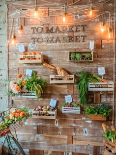 an indoor market with lots of fresh vegetables and fruits on display in wooden crates hanging from the wall