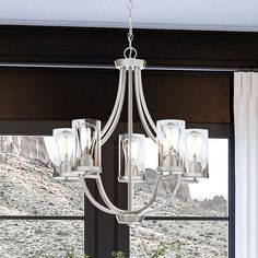 An urban ambiance lighting fixture in a living room with a beautiful view of a large window. Chandelier Brushed Nickel, Indoor Chandelier, Transitional Chandeliers, Indoor Wall Sconces, Luxury Contemporary, Contemporary Chandelier, Bath Light, Chandelier For Sale, Lighting Store