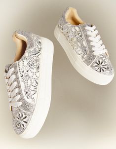 Put a little sparkle in your step with the REILY rhinestone sneakers. This sneaker can be paired with your best dress or favorite jean! Its intricate pattern is an eye-catching way to make a statement, no matter where you're wearing it. Manmade rhinestone platform sneakers Lace up closure Textile lining Rubber sole 1.5 inch platform Imported