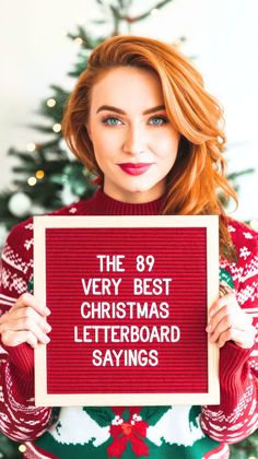 a woman holding up a sign that says the 89 very best christmas letter board sayings