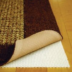 a close up of a rug on the floor with a roll of fabric next to it