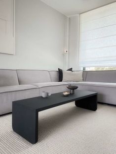 a living room with a couch, coffee table and window