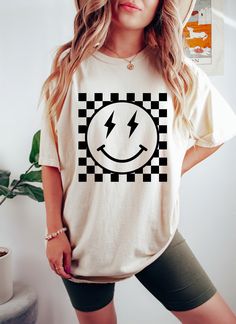 Checkered Pattern Smiley Face Oversized Vintage T-Shirt, Retro Smiley Face Shirt, Lightning Smiley Face Shirt, Smile Shirt, Comfort Colors This oversized Comfort Colors shirt is perfect for chill days, and the mineral wash gives it a rad vintage feel.  You'll love this tee's slouchy fit and cool design.  CARE INSTRUCTIONS Wash items inside cold water, do not bleach, dry clean, and iron directly on the design. Tumble dry low. PRODUCTION AND SHIPPING The standard production time is 1-3 business days. (We usually process and ship out the orders within two business days.) USA Orders: Standard: 2 to 6 days to get delivered (after processing time) Priority: 1 to 4 days to get delivered (after processing time) Express: 1 to 2 days to get delivered (after processing time)    If you need the item s Smily Face Shirt, Smiley Face Lightning Bolt Cake, Smiley Face Hat Outfit, Smile Face Shirt, Checkered T Shirt, Smiley Tshirt Design, Smiley Face 3rd Birthday, Smiley Shirt Design, Smile T Shirt