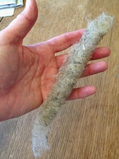 a person holding something in their hand on a wooden table