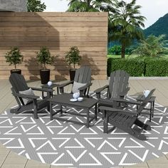 an outdoor patio area with chairs, tables and potted plants on the rug in front of a wooden wall