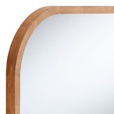 an arched wooden mirror frame on a white background with reflection in the mirror and wood trim around it