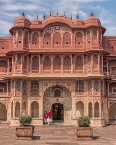 two people standing in front of a large building