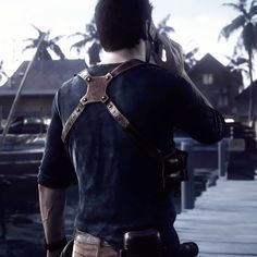 a man standing on top of a pier next to a boat in the ocean with palm trees behind him