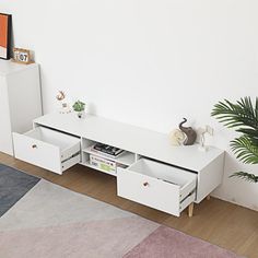 a living room with white furniture and a plant