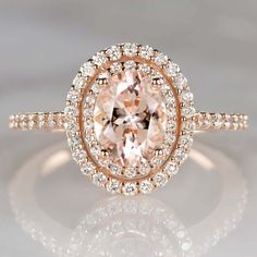 an oval cut peach morganite surrounded by white and brown diamonds in a rose gold halo setting